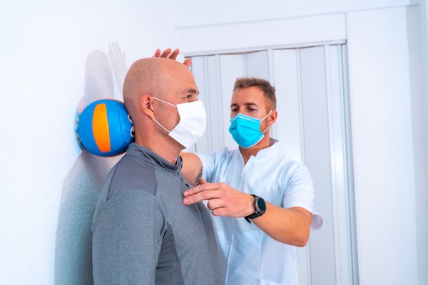 Physiotherapist examining patient's shoulder